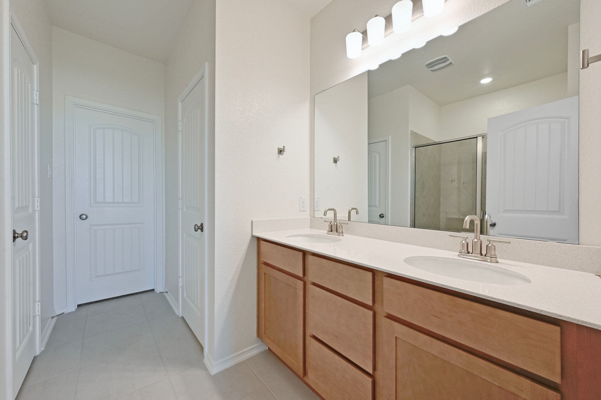 15004 Garrano Way Manor, TX 78653 - Photo 17 of 34 a bathroom with a double vanity sink mirror and
