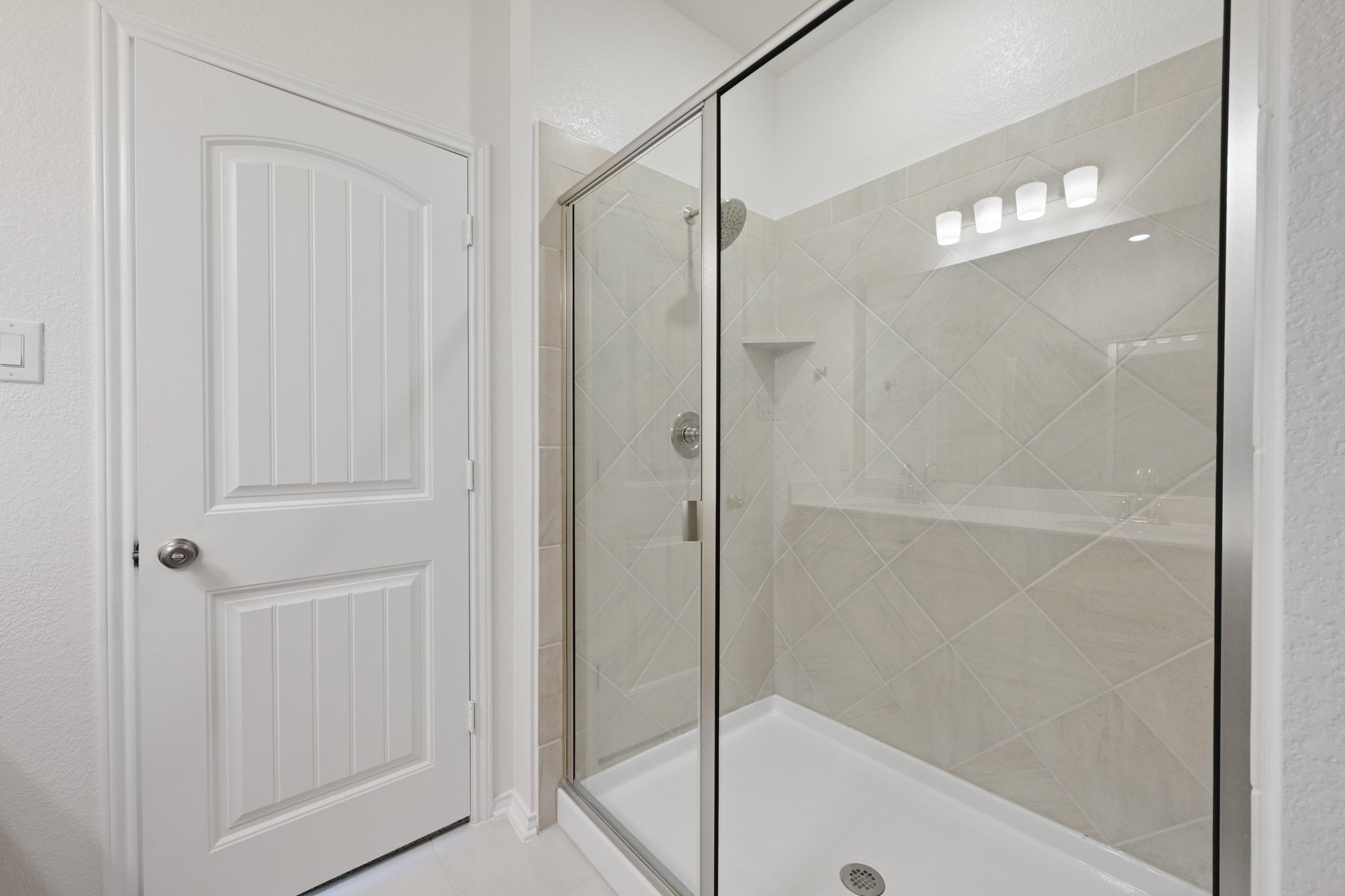 15004 Garrano Way Manor, TX 78653 - Photo 18 of 34 a bathroom with a glass shower door and a glass door