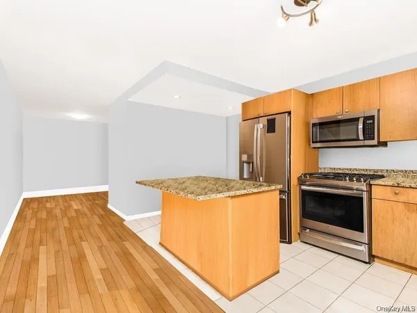 a kitchen with stainless steel appliances granite countertop a stove a refrigerator and a microwave