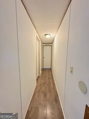 en empty room with wooden floor and windows