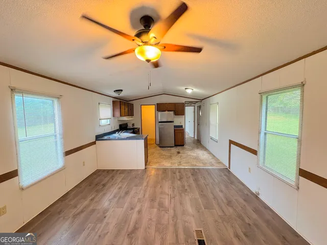 a kitchen with granite countertop a refrigerator and a stove top oven