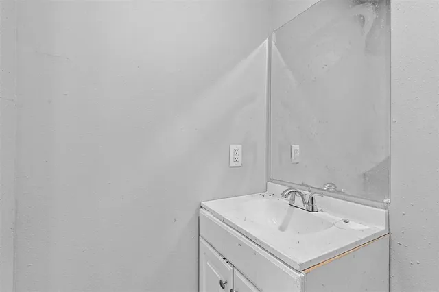 a backyard of a house with plants and large tree