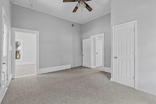 an empty room with chandelier fan