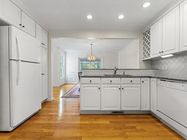 a kitchen with kitchen island granite countertop a refrigerator and a sink