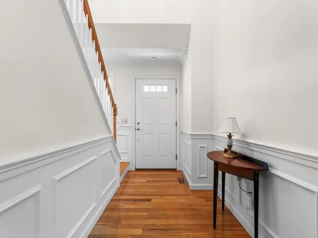 a view of a hallway with wooden floor and staircase
