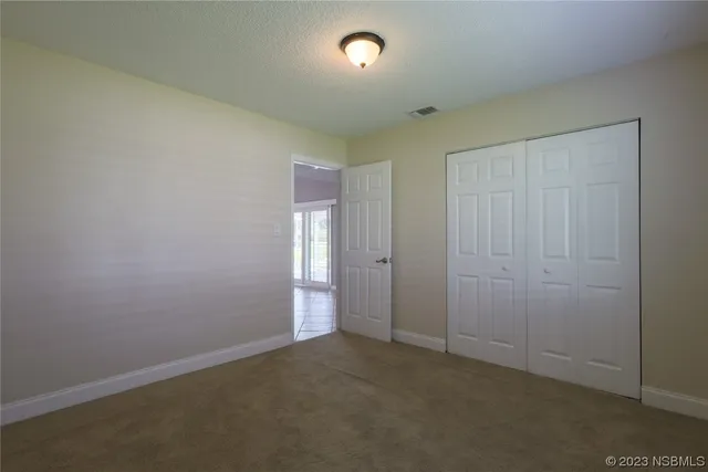 an empty room with windows and closet