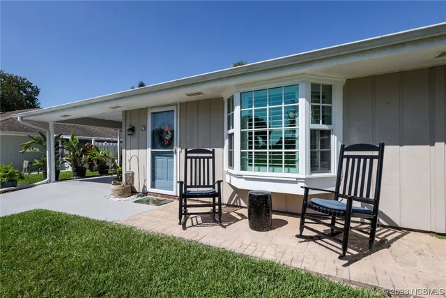 a view of a house with backyard and sitting area