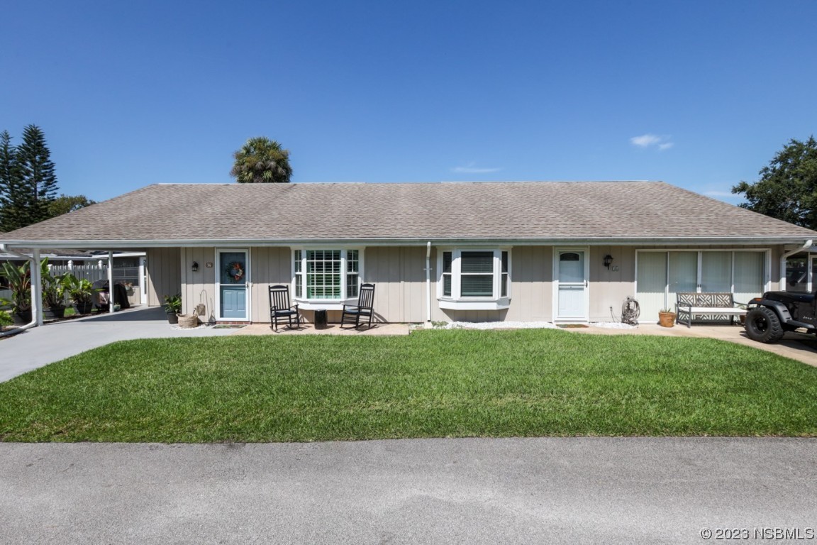 14 Chip Lane New Smyrna Beach, FL 32168 - Photo 28 of 54 a front view of a house with a yard porch and outdoor seating
