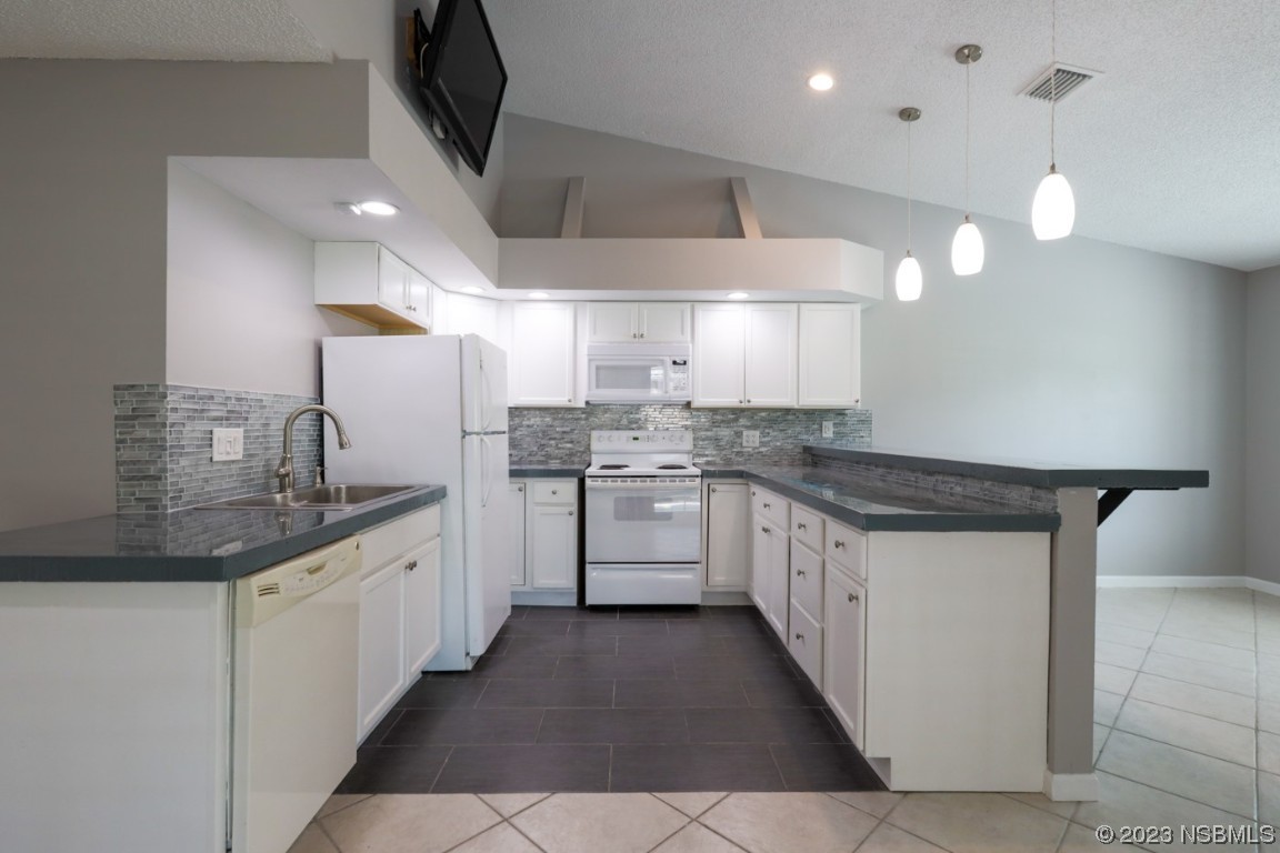 14 Chip Lane New Smyrna Beach, FL 32168 - Photo 37 of 54 a kitchen with stainless steel appliances a sink stove and cabinets