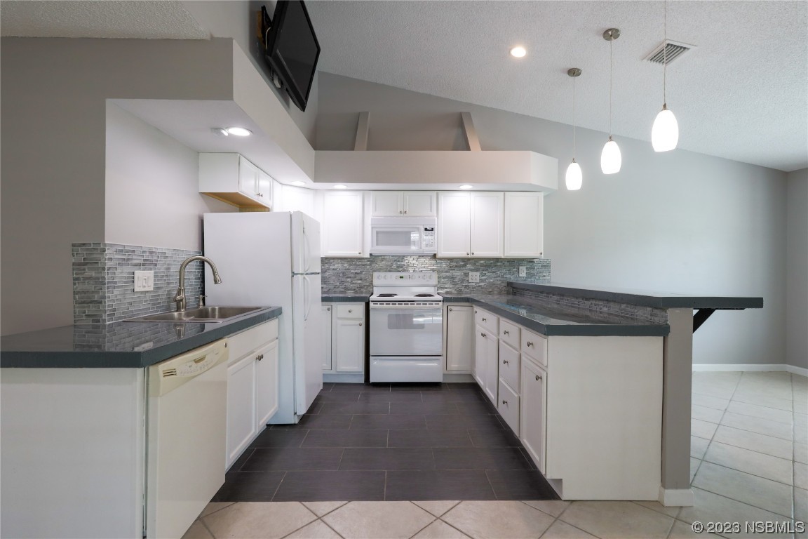 14 Chip Lane New Smyrna Beach, FL 32168 - Photo 9 of 54 a kitchen with stainless steel appliances a sink stove and cabinets