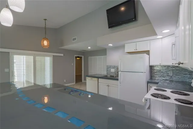 a kitchen with stainless steel appliances kitchen island granite countertop a stove a sink a refrigerator and a microwave