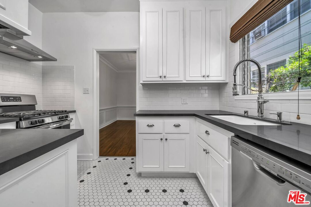 360 South Roxbury Drive Beverly Hills, CA 90212 - Photo 11 of 30 a kitchen with granite countertop a sink stainless steel appliances and cabinets