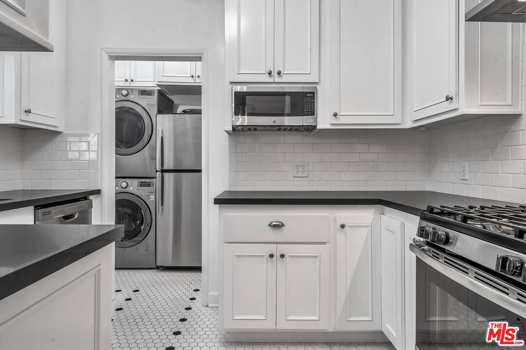 360 South Roxbury Drive Beverly Hills, CA 90212 - Photo 12 of 30 a kitchen with white cabinets and stainless steel appliances