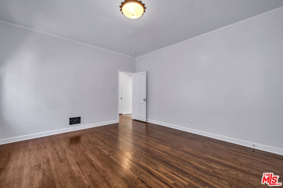 360 South Roxbury Drive Beverly Hills, CA 90212 - Photo 17 of 30 a view of an empty room with wooden floor and window