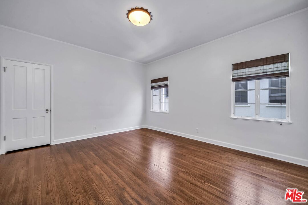 360 South Roxbury Drive Beverly Hills, CA 90212 - Photo 18 of 30 a view of an empty room with wooden floor and a window