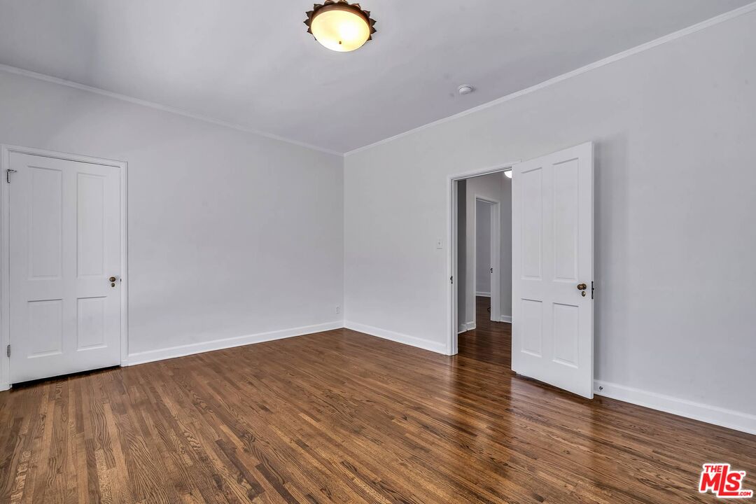 360 South Roxbury Drive Beverly Hills, CA 90212 - Photo 19 of 30 a view of an empty room with wooden floor and window
