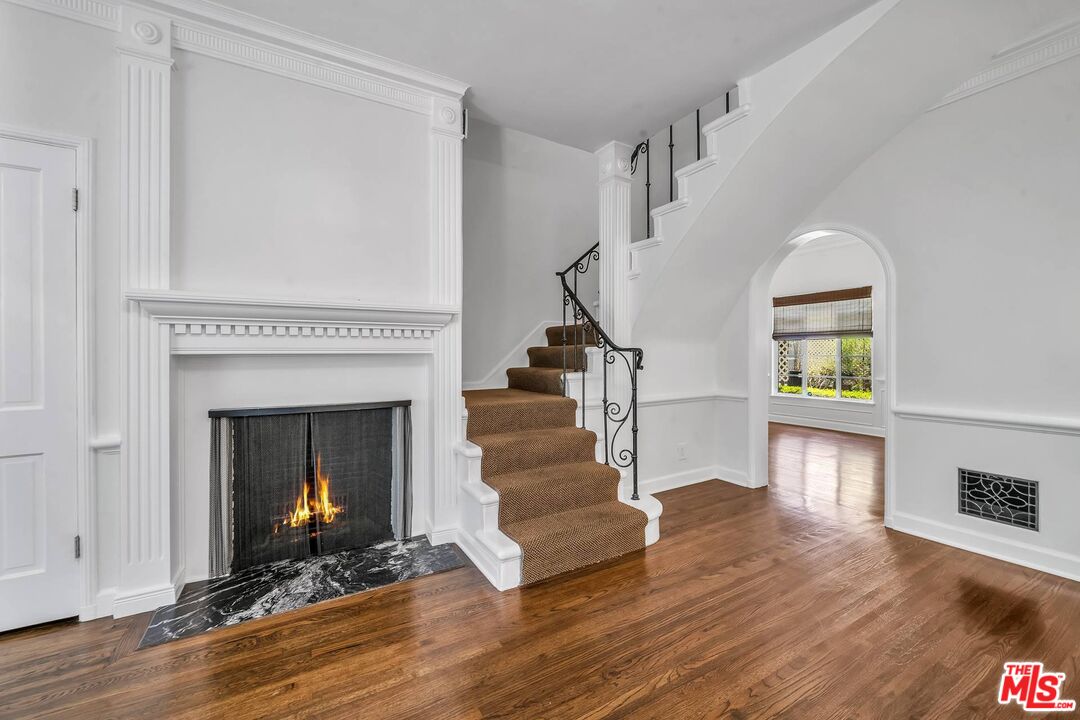 360 South Roxbury Drive Beverly Hills, CA 90212 - Photo 2 of 30 a living room with wooden floors and a fireplace