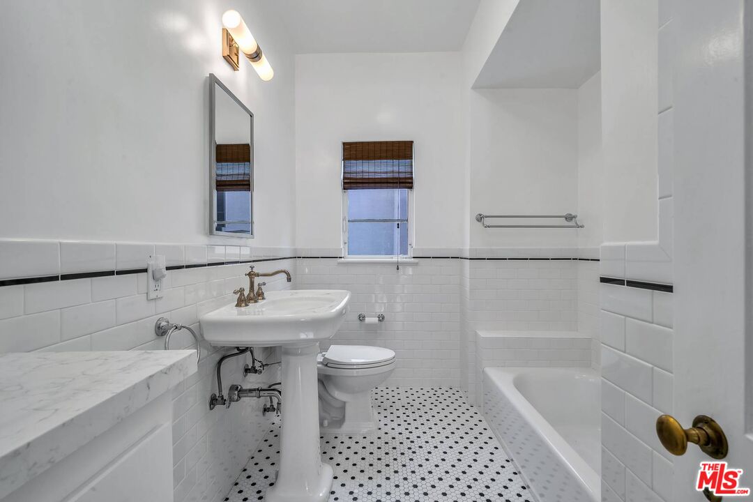 360 South Roxbury Drive Beverly Hills, CA 90212 - Photo 21 of 30 a bathroom with a sink a toilet a mirror and shower