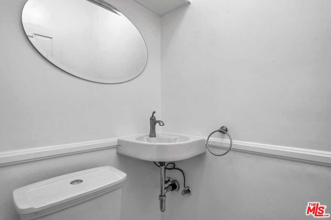 360 South Roxbury Drive Beverly Hills, CA 90212 - Photo 23 of 30 a bathroom with a sink a toilet and a mirror