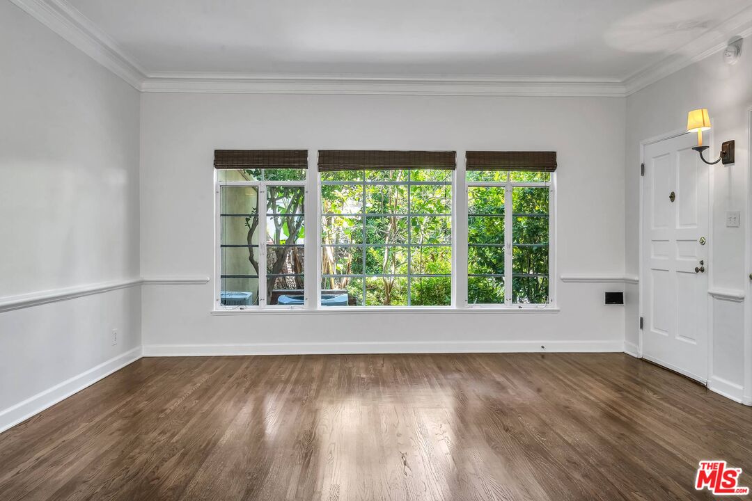 360 South Roxbury Drive Beverly Hills, CA 90212 - Photo 4 of 30 a view of an empty room with wooden floor and a window