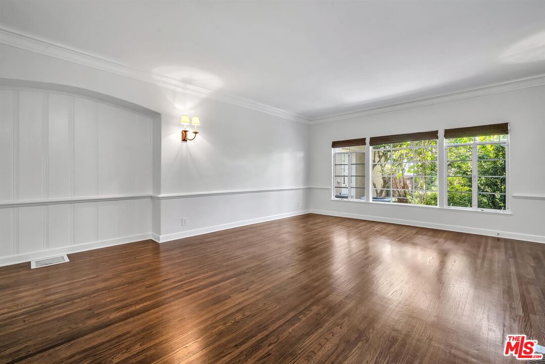 360 South Roxbury Drive Beverly Hills, CA 90212 - Photo 6 of 30 an empty room with wooden floor and windows