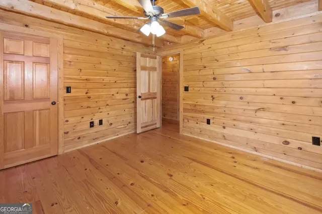 a view of a small house with wooden fence in a yard