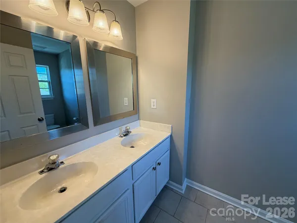 a bathroom with a double vanity sink and a mirror