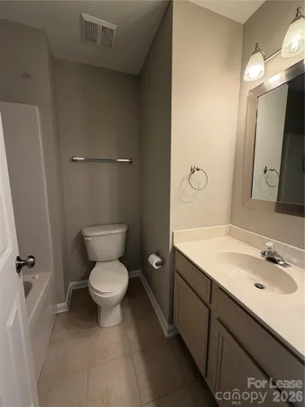 a bathroom with a granite countertop toilet sink and mirror