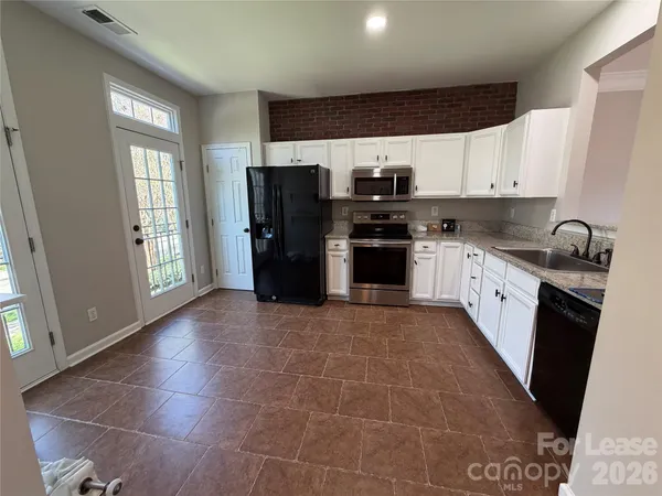 a kitchen with stainless steel appliances a refrigerator stove microwave and sink
