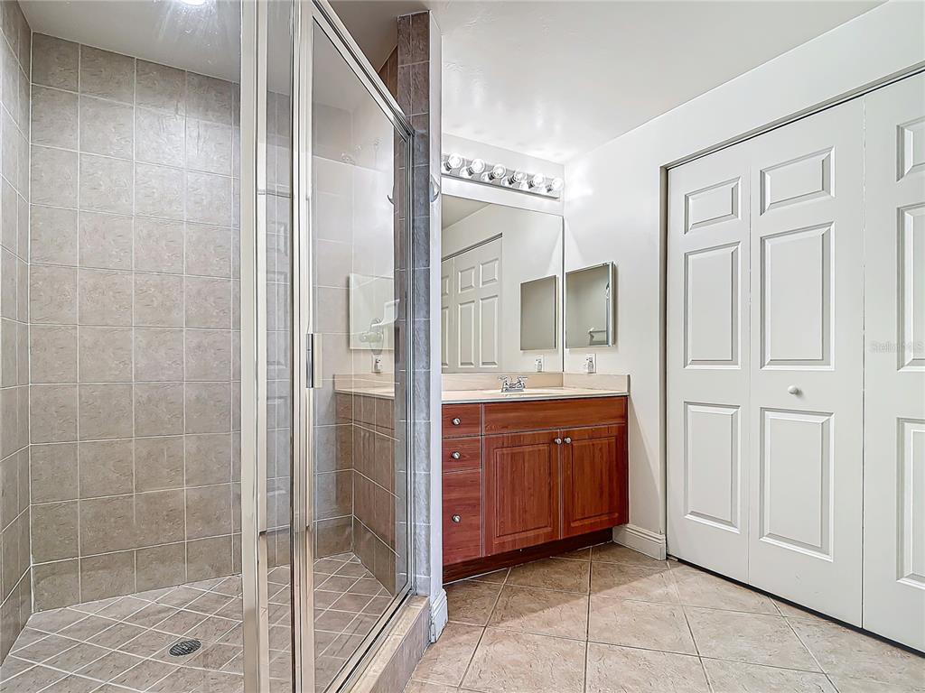 2745 First Street, Unit 111 Fort Myers, FL 33916 - Photo 30 of 79 a spacious bathroom with a granite countertop sink a mirror and a shower