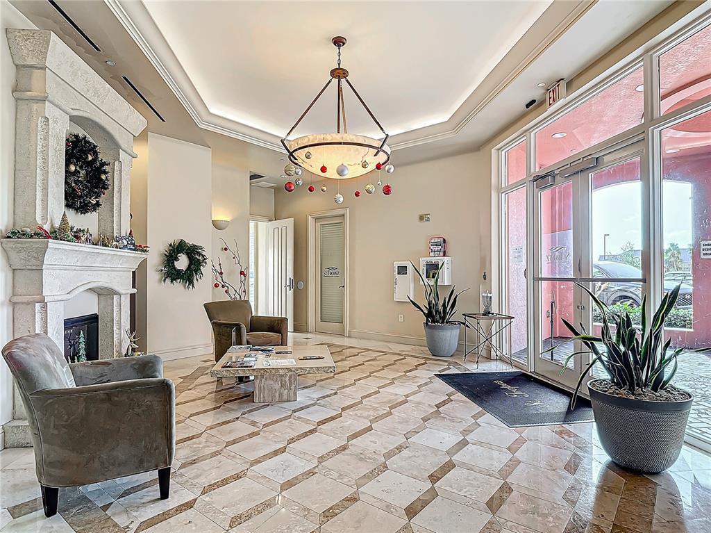 2745 First Street, Unit 111 Fort Myers, FL 33916 - Photo 35 of 79 a living room with furniture a chandelier and a fireplace