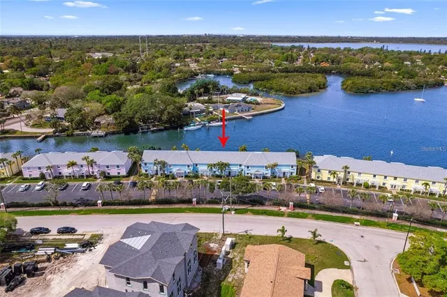 an aerial view of ocean and residential houses with outdoor space