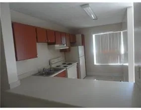 a kitchen with stainless steel appliances a refrigerator a stove a sink and a window