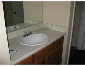 a bathroom with a granite countertop toilet sink and mirror