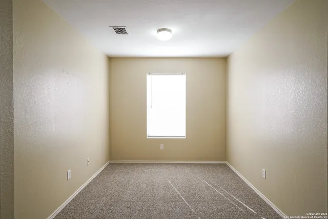 an empty room with a window and a mirror