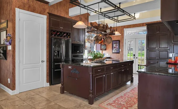 a kitchen with granite countertop stainless steel appliances a sink and a counter top space