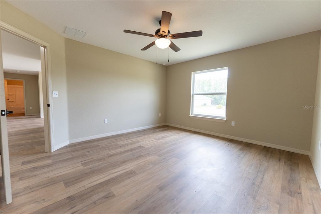 14686 Southwest 79th Avenue Road Ocala, FL 34473 - Photo 11 of 42 an empty room with wooden floor and windows