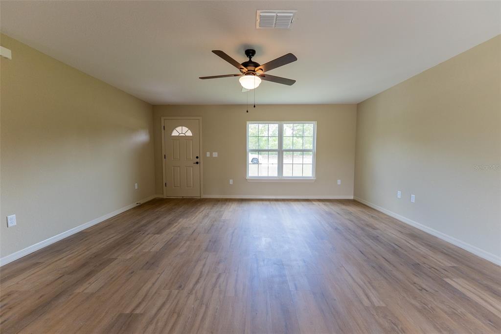 14686 Southwest 79th Avenue Road Ocala, FL 34473 - Photo 5 of 42 wooden floor in an empty room with a window