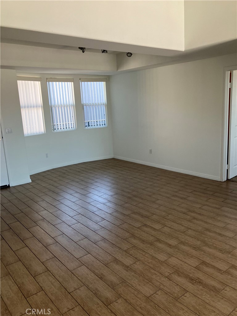 11925 Kling Street, Unit 111 Valley Village, CA 91607 - Photo 3 of 16 an empty room with wooden floor and windows