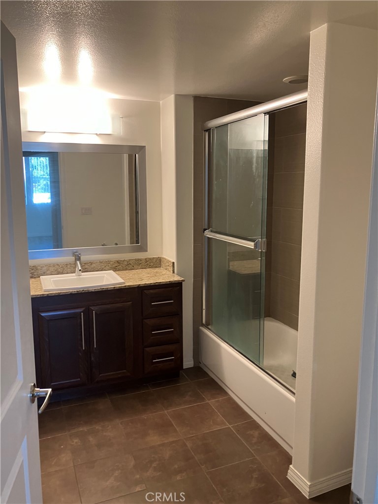 11925 Kling Street, Unit 111 Valley Village, CA 91607 - Photo 5 of 16 a bathroom with a double vanity sink and a mirror