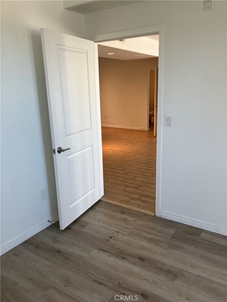 11925 Kling Street, Unit 111 Valley Village, CA 91607 - Photo 10 of 16 an empty room with wooden floor and closet