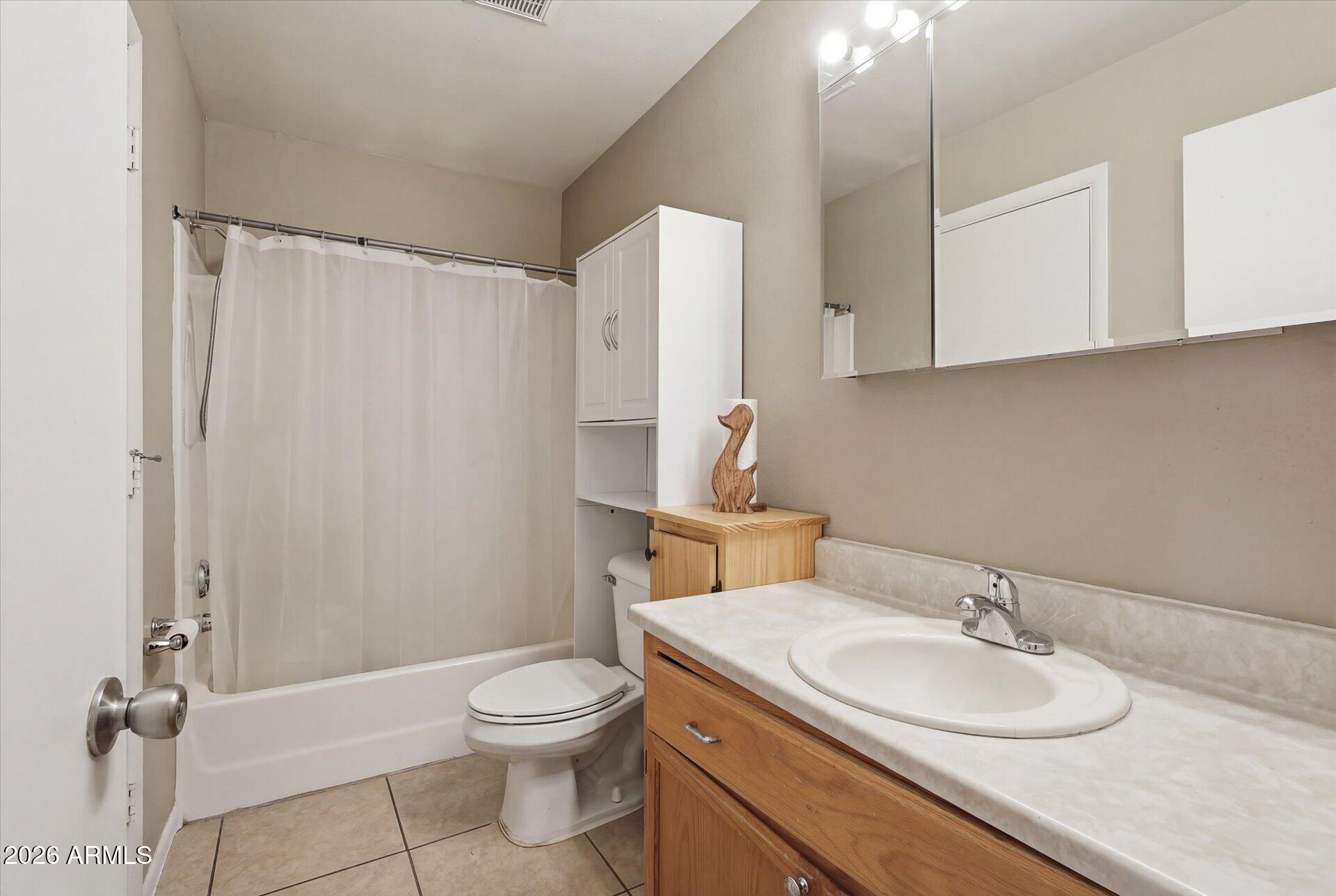 3270 South Goldfield Road, Unit 716 Apache Junction, AZ 85119 - Photo 14 of 36 a bathroom with a granite countertop sink toilet a mirror and shower