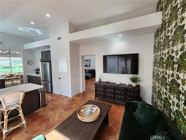 a living room with furniture and a dining table with kitchen view