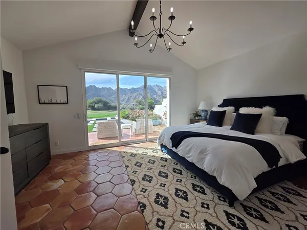 a spacious bedroom with a bed and wooden floor