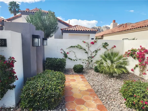 a white house with a flower garden