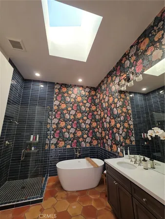 a bathroom with a granite countertop bathtub shower sink mirror and toilet