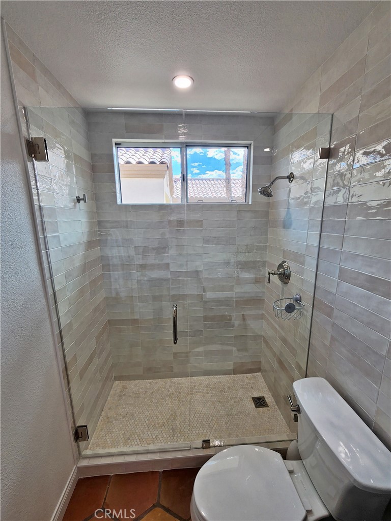 56989 Merion La Quinta, CA 92253 - Photo 34 of 37 a bathroom with a granite countertop bathtub shower sink mirror and toilet