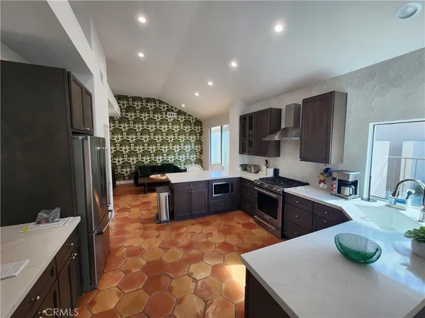 a large kitchen with a counter top space a sink a stove and refrigerator