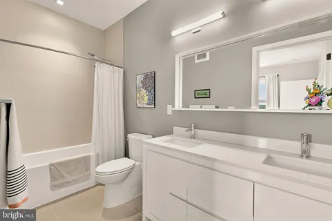 a bathroom with a sink toilet vanity and shower