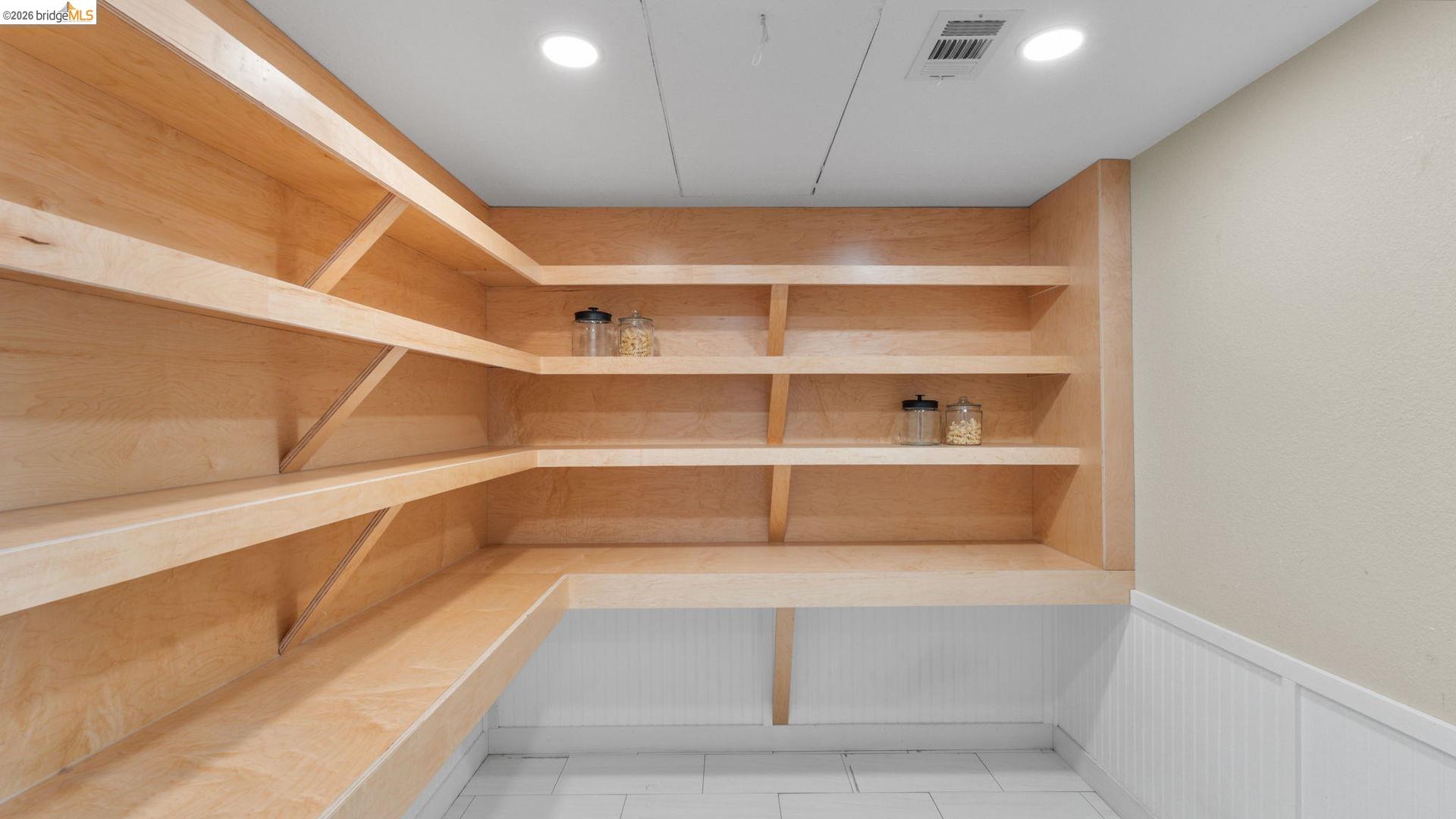 700 Brownstone Road Oakley, CA 94561 - Photo 24 of 58 Expansive pantry featuring light wood-finish shelving, an integrated countertop workspace, white wainscoting, and recessed ceiling lighting